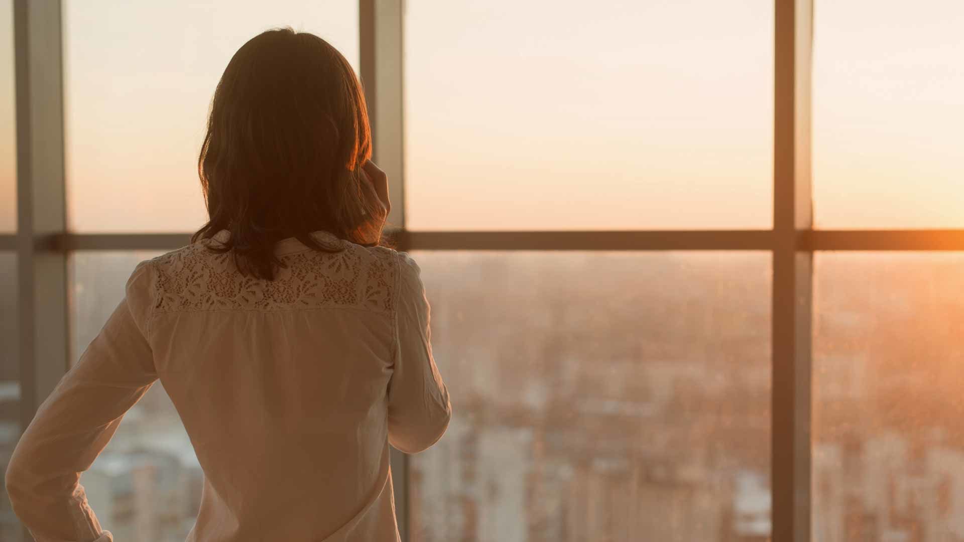 Frau schaut aus dem Fenster