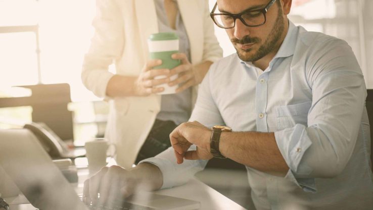Mann schaut auf die Uhr_ Zeitwirtschaft